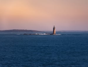 body of water and gray concrete lighthouse thumbnail