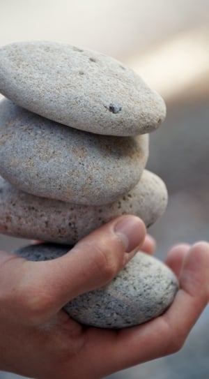 persons hand holding four stone on close up photography thumbnail