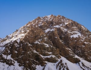 brown mountain formation surrounded by white snows during daytime thumbnail
