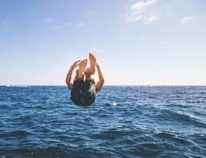 human falling down to body of water during daytime thumbnail
