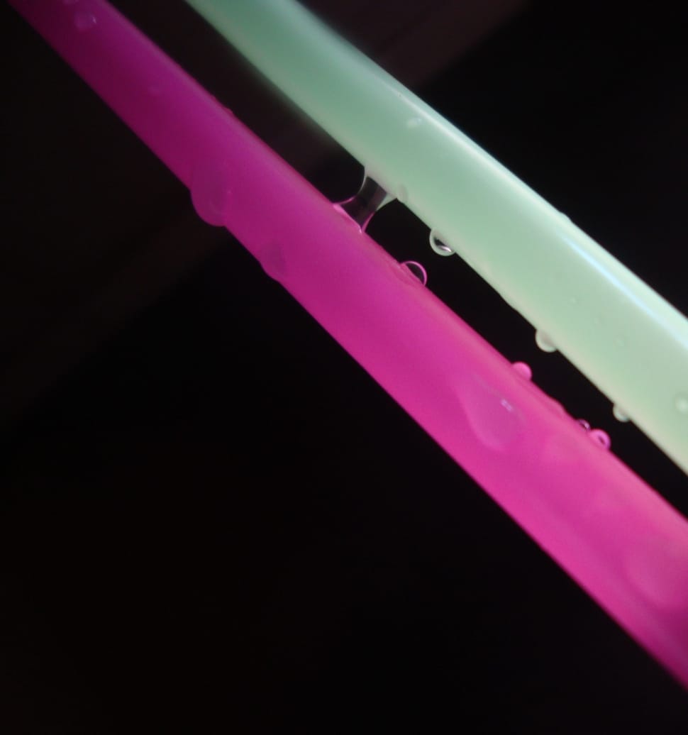 pink and green plastic straw with water droplets preview
