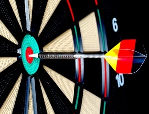 yellow, red and black dart marked on the bull's eye target of dart board thumbnail