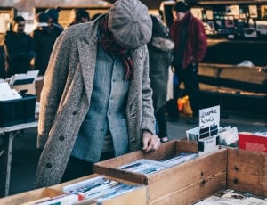 man in grey coat looking at the books thumbnail