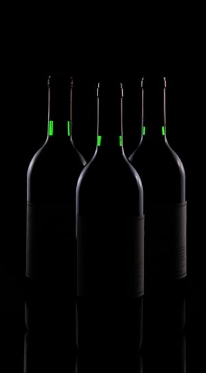 three black bottles on top of black surface thumbnail