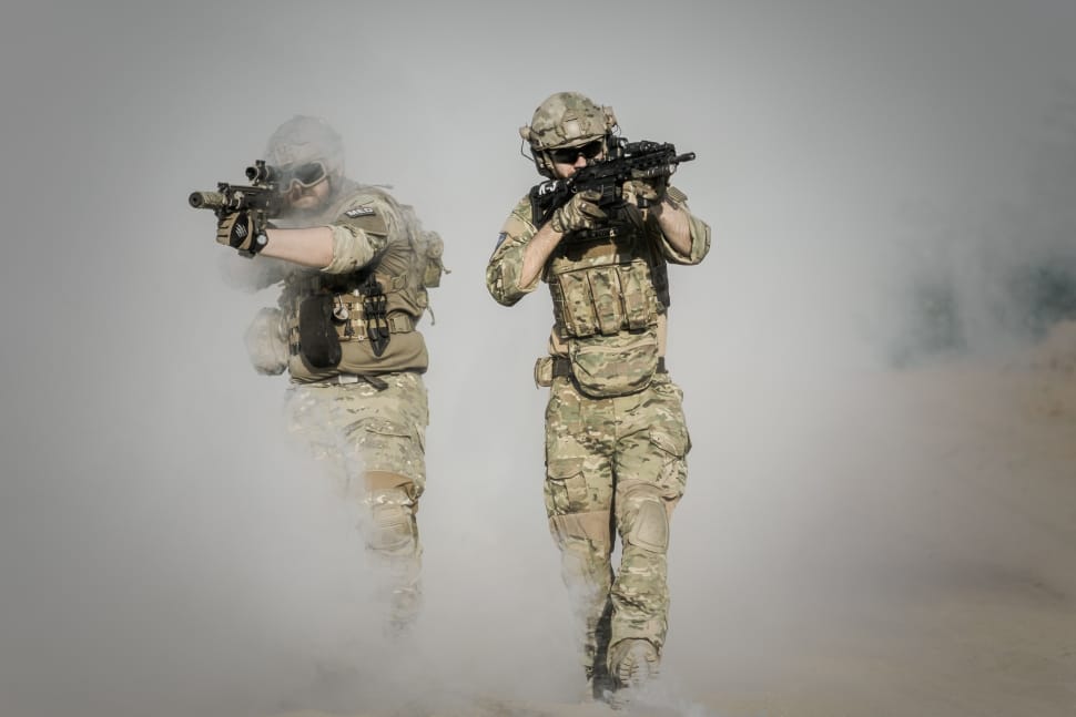 two military men coming out of smoke holding up rifles preview