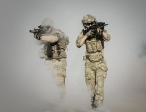 two military men coming out of smoke holding up rifles thumbnail