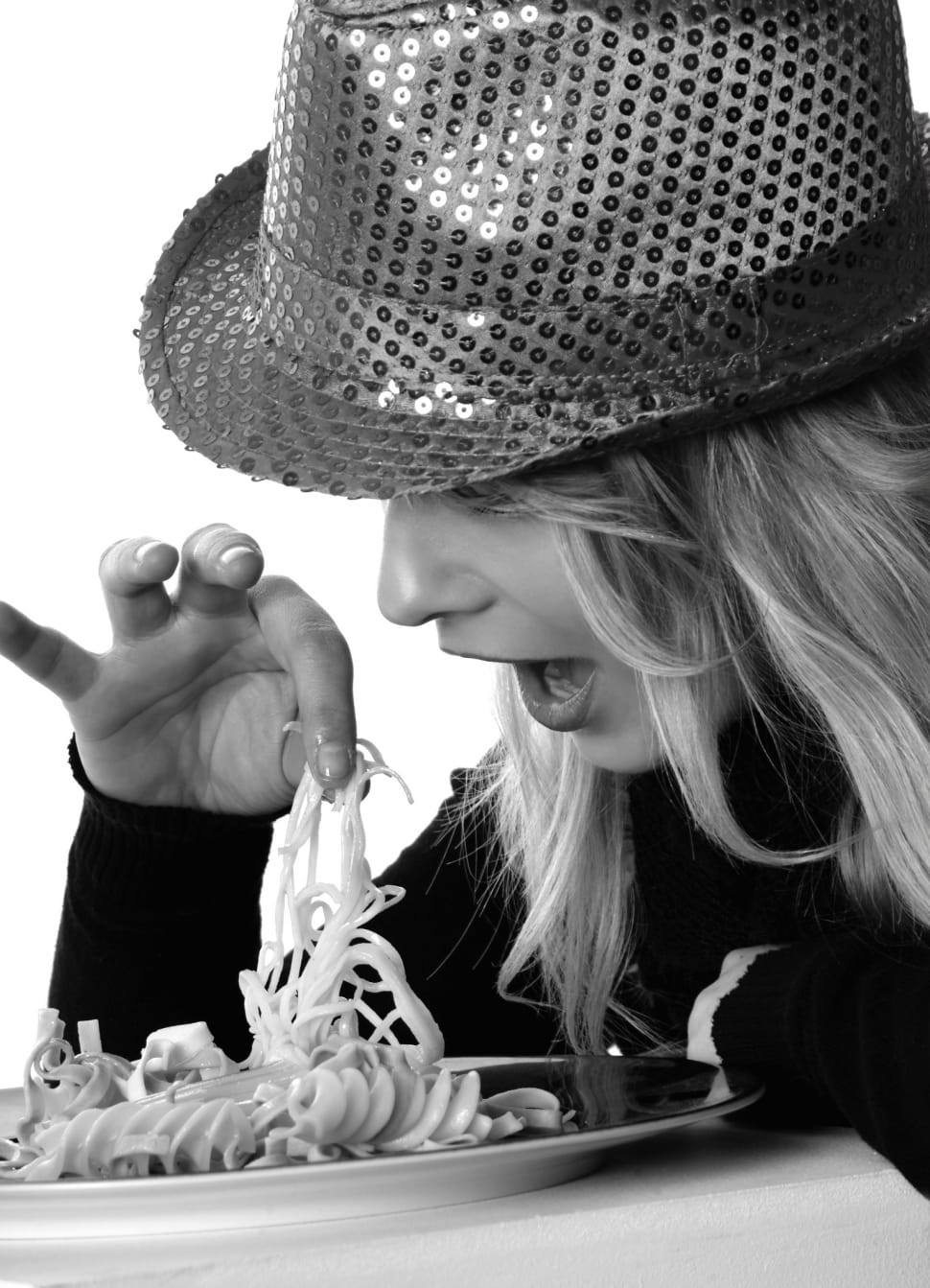 gray scale photo of woman holding pasta wearing hat and long sleeves shirt preview