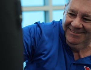 smiling man wearing blue polo shirt thumbnail