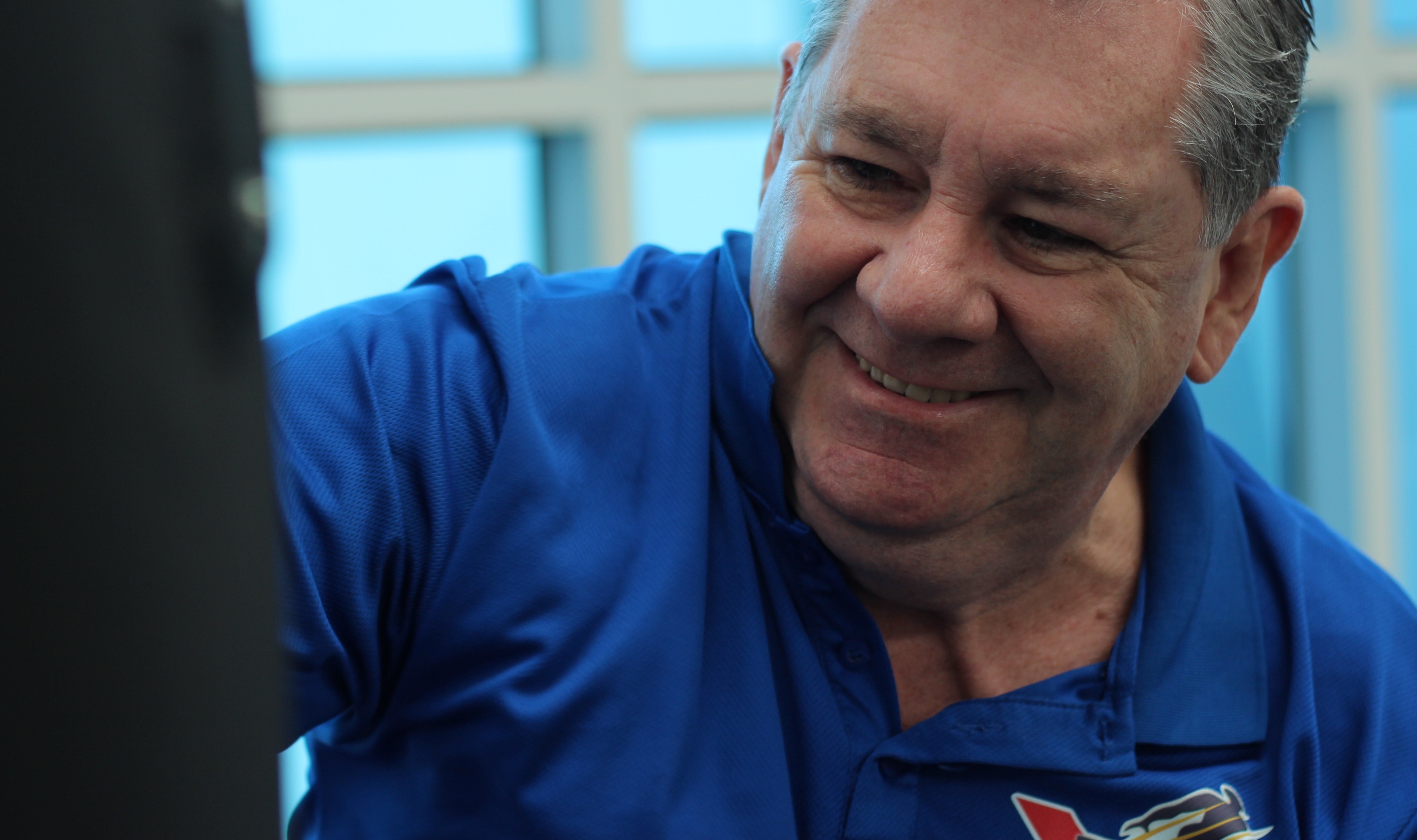smiling man wearing blue polo shirt