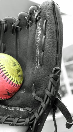 black leather baseball mitts and yellow and pink baseball thumbnail