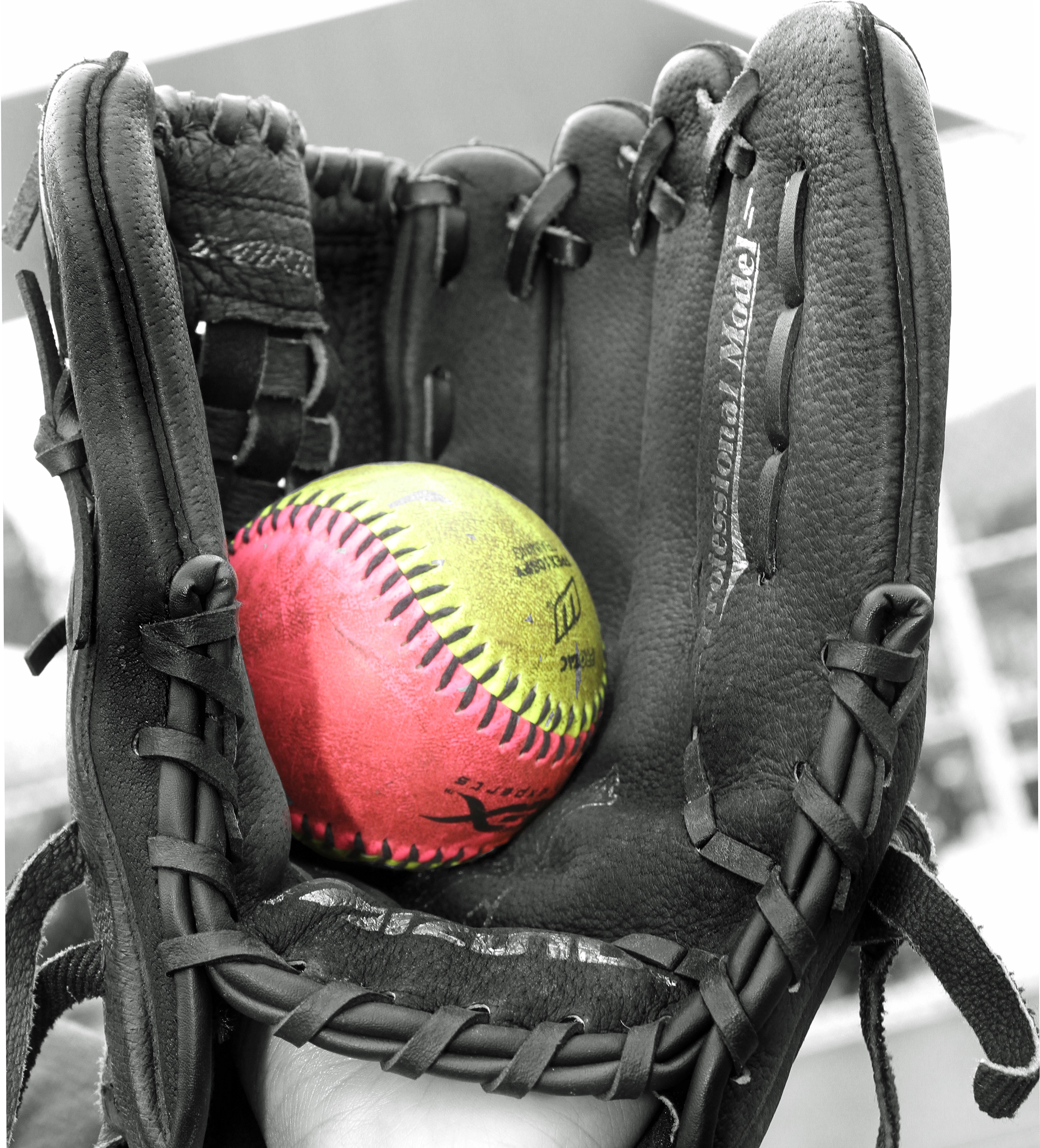 black leather baseball mitts and yellow and pink baseball