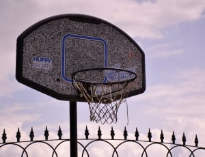 grey and blue basketball system near black metal fence' thumbnail