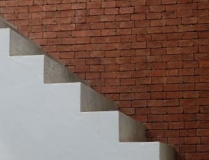 white concrete stairs and brown bricked wall thumbnail