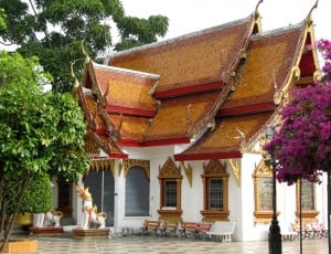 white, brown and red temple near trees at daytime thumbnail