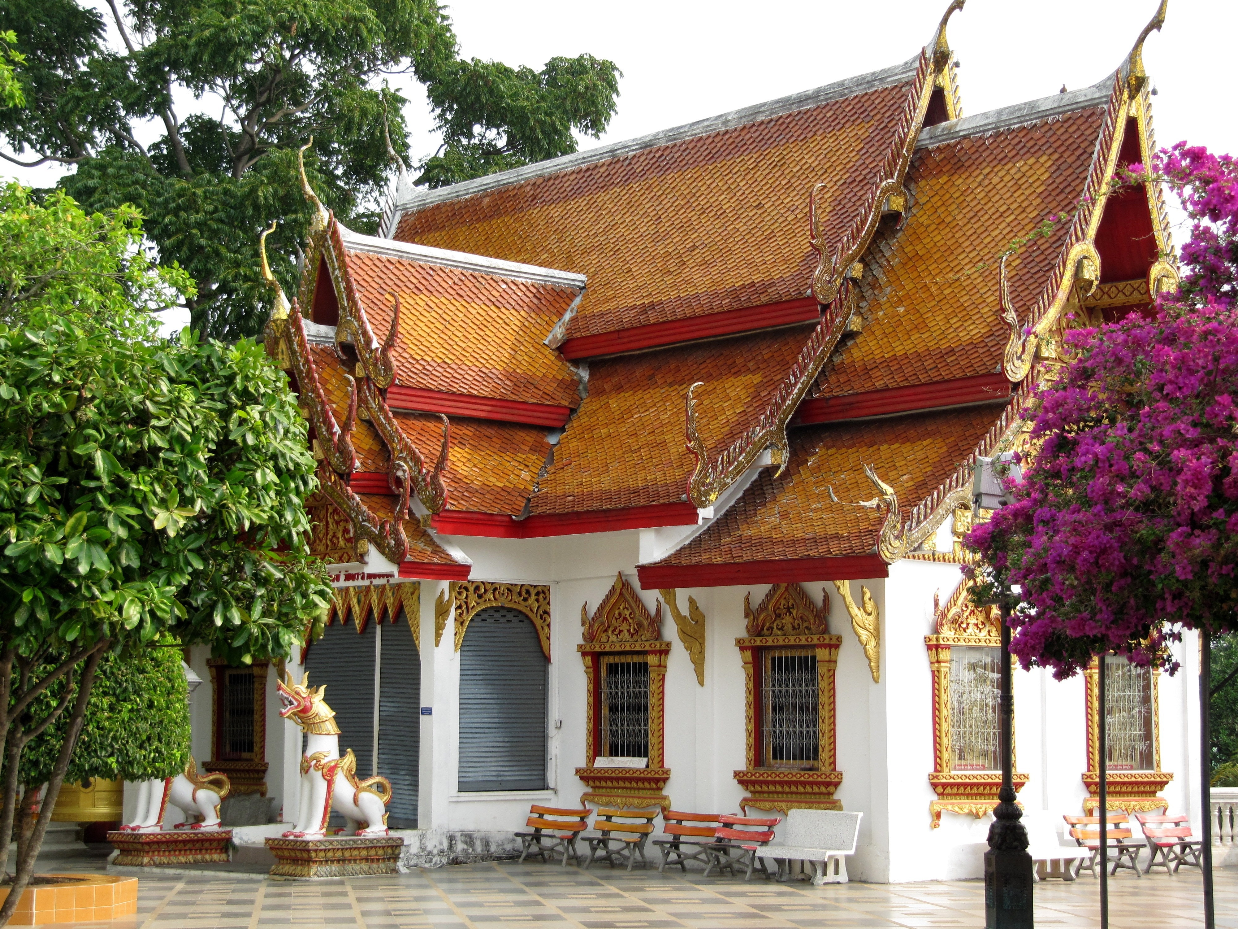 white, brown and red temple near trees at daytime