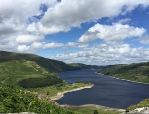 green mountain near the lake aerial photo during daytime thumbnail