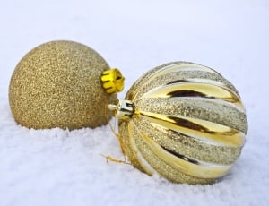 two gold christmas balls on snow thumbnail