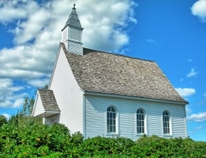 white concrete chapel with tower and gray roof thumbnail