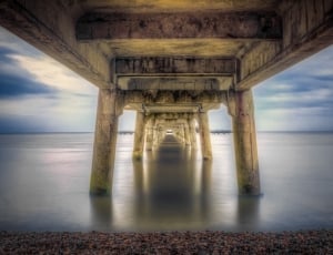 architectural photography of brown concrete bridge near body of water thumbnail