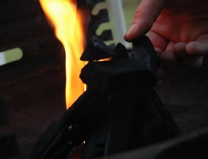 person holding charcoal near flame thumbnail
