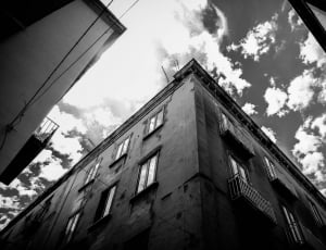 grayscale photo of building and clouds thumbnail