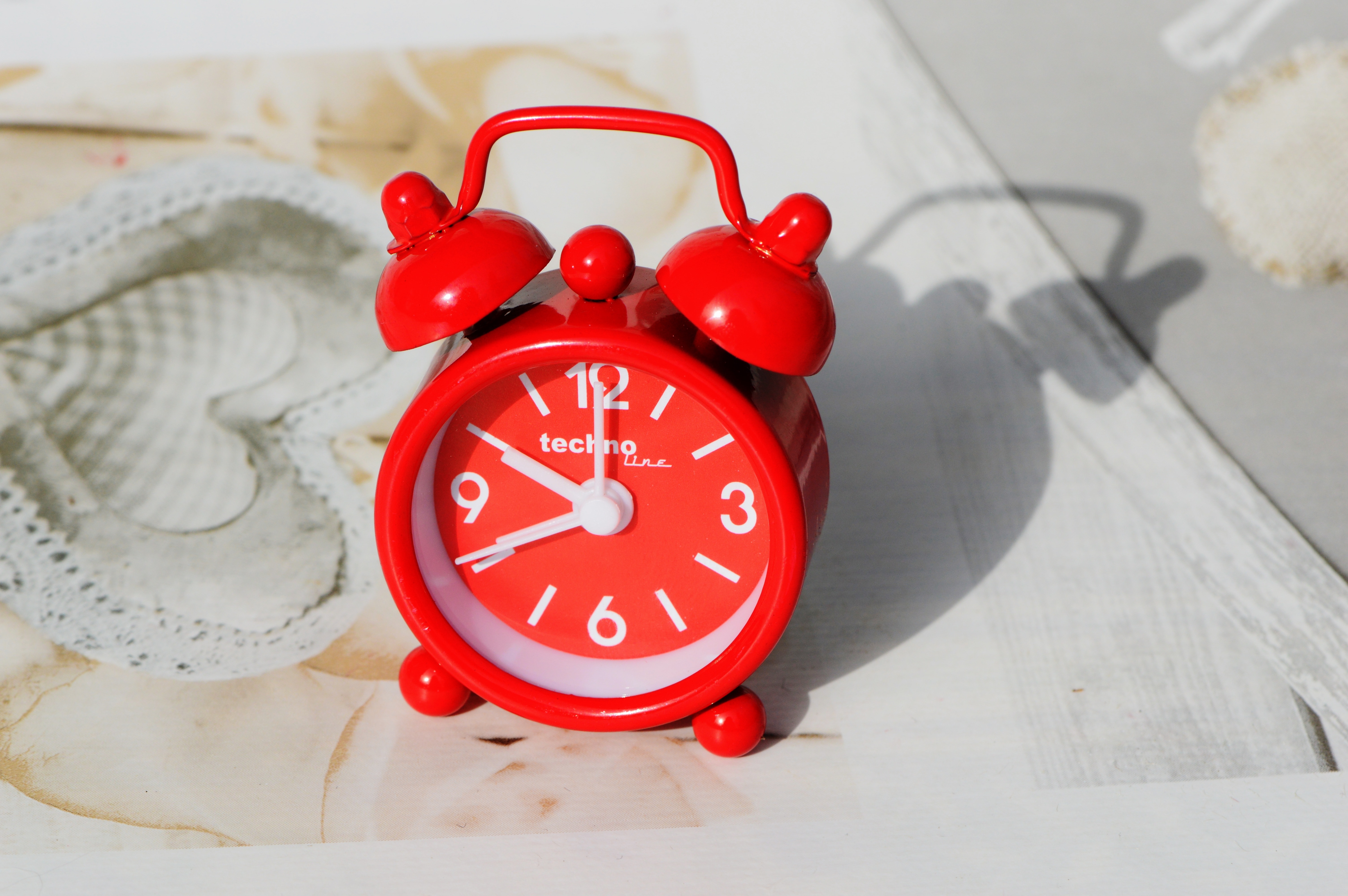 red and white bell alarm clock