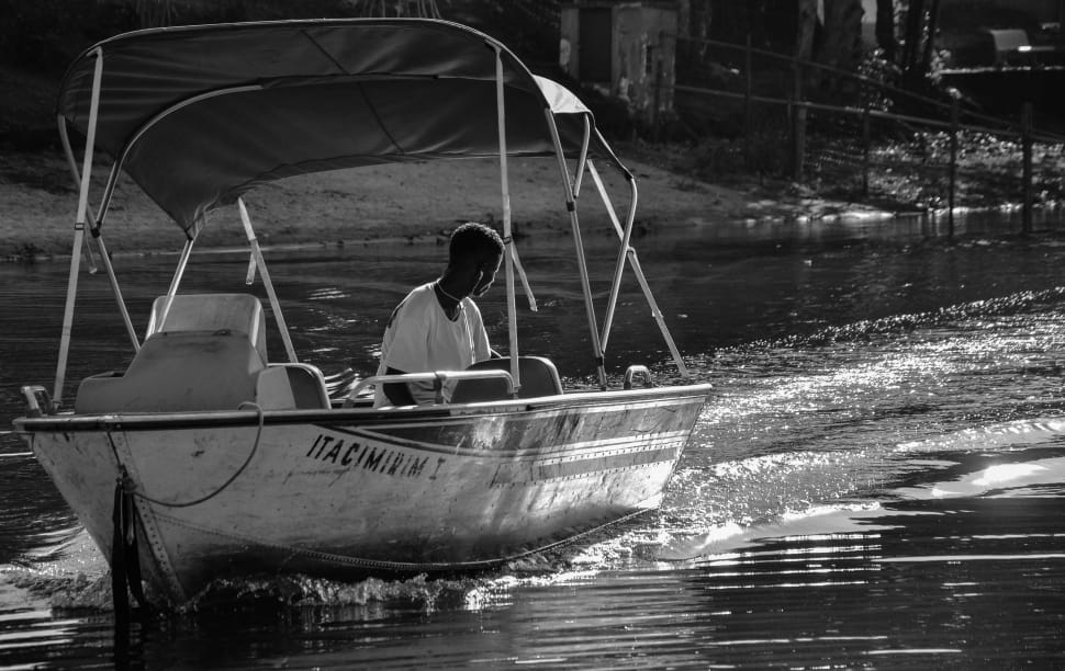 grayscale photo of power boat cruising the river preview