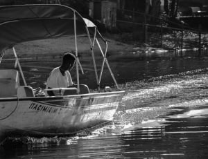 grayscale photo of power boat cruising the river thumbnail