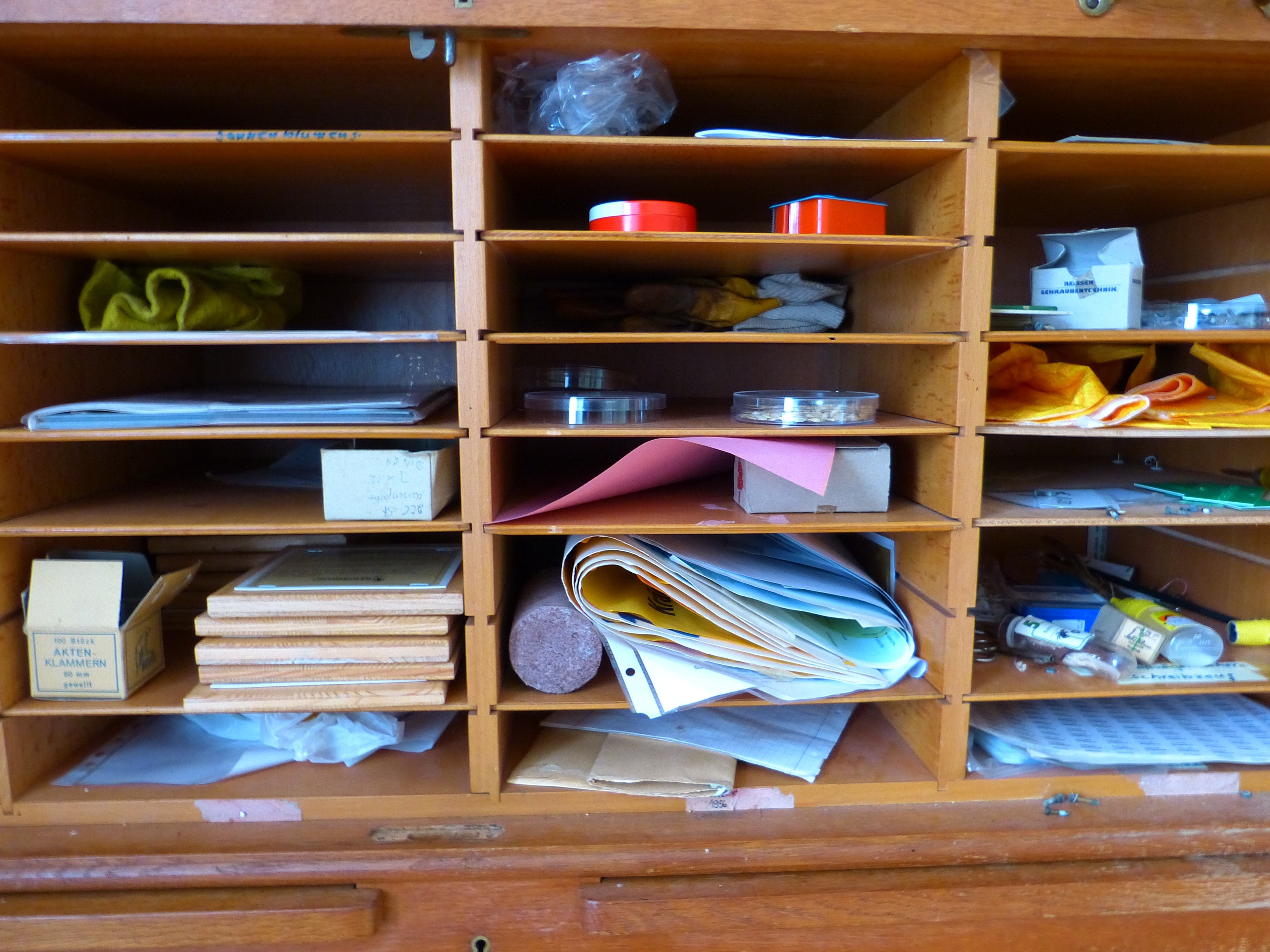 papers, boxes, and boards in brown wooden shelf