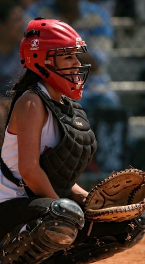 brown leather baseball mitt and red baseball helmet thumbnail