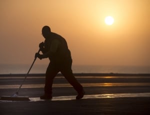 silhouette of man sweeping the floor thumbnail