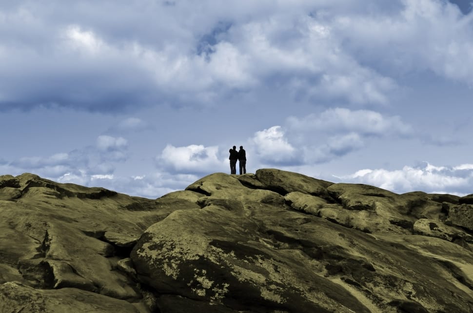 silhouette of two person on brown hills preview