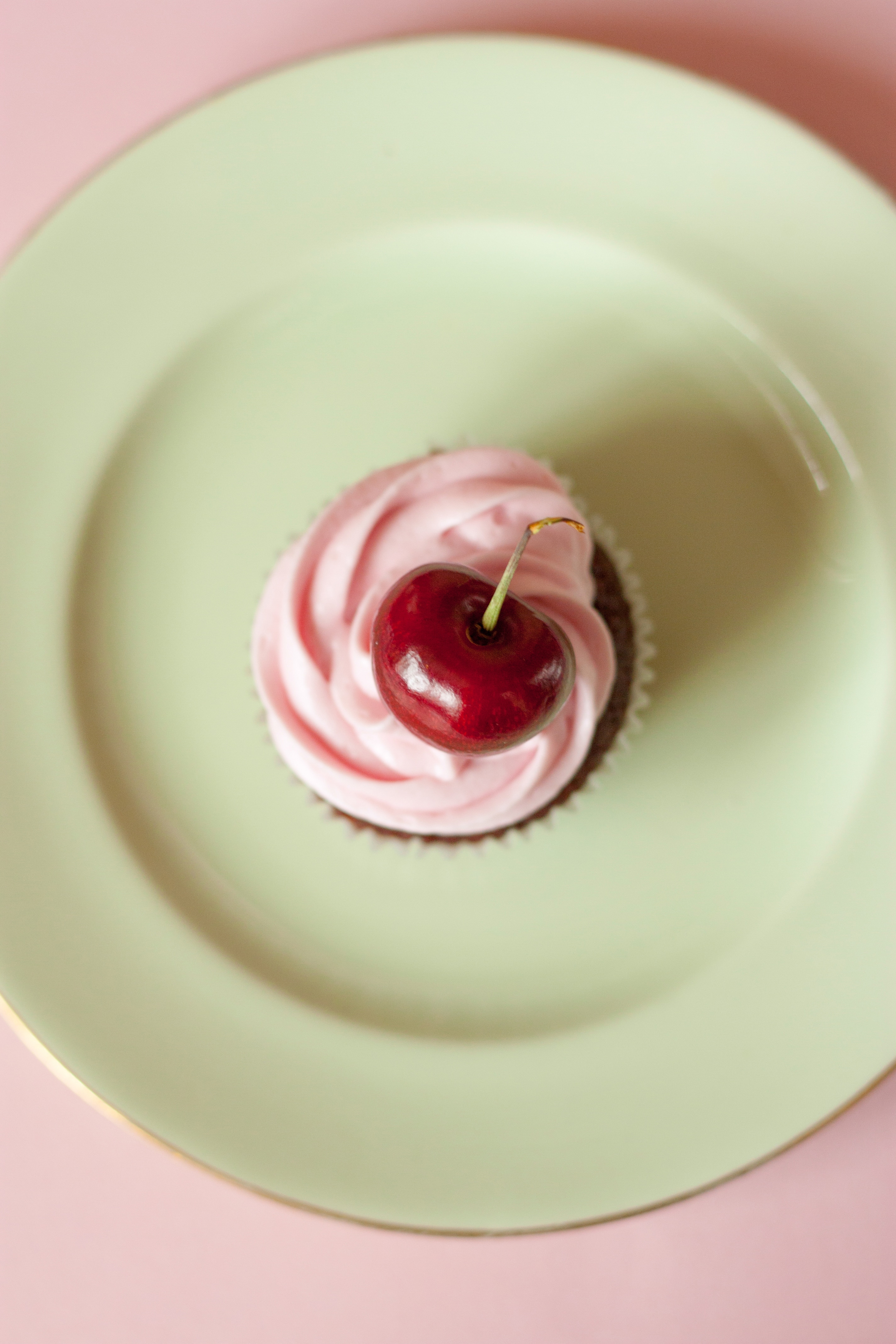 cherry cupcake on green ceramic plate