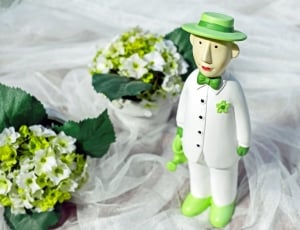 man in green hat and white dress shirt and pants ceramic figurine thumbnail
