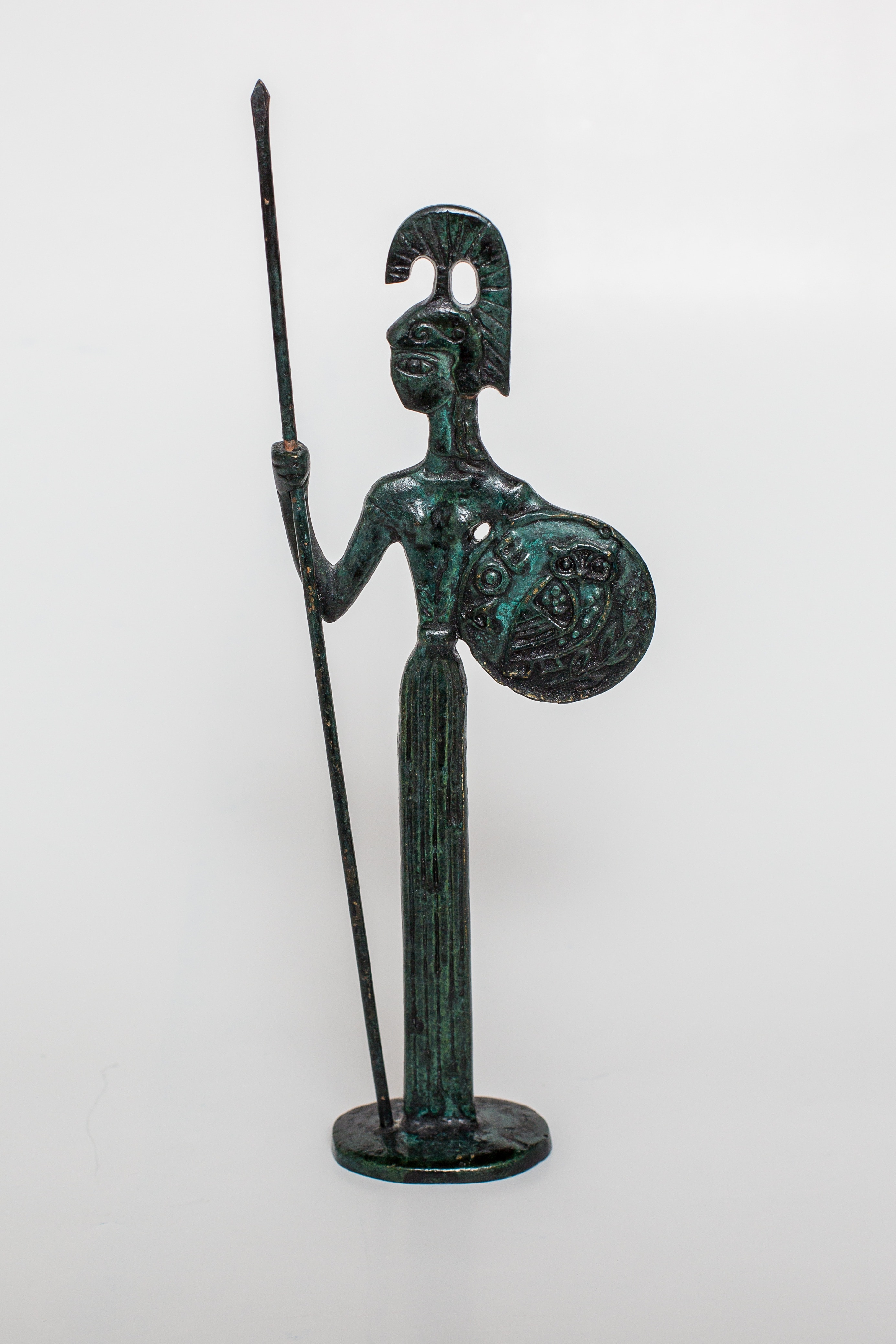 person holding spear and shield figurine