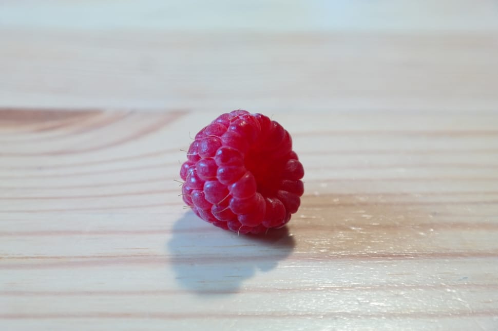 red raspberry on brown wooden surface preview