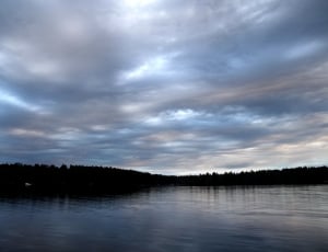 body of water under clouds during sunset thumbnail