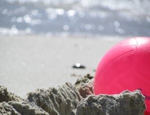 red ball on sand at daytime thumbnail