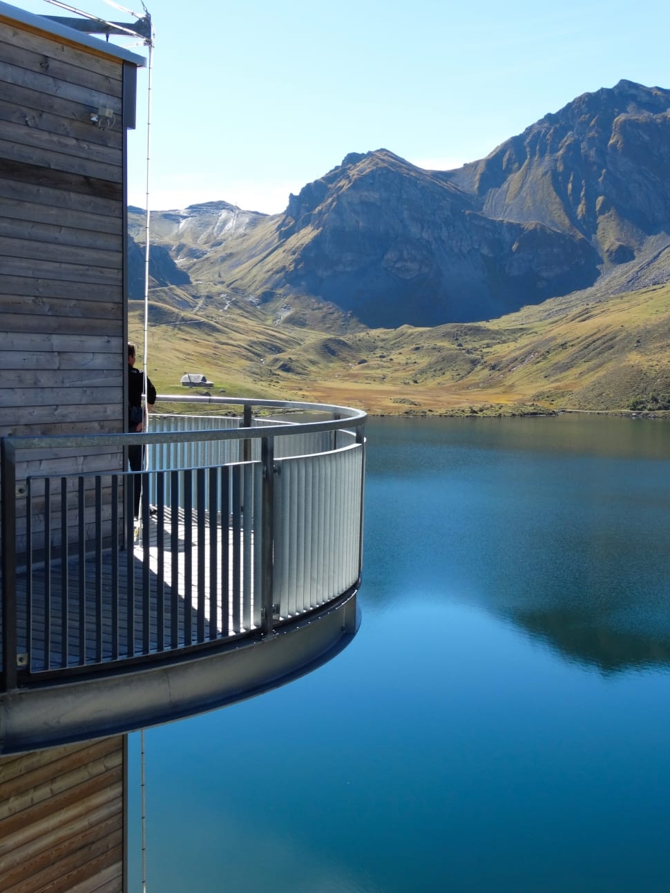architectural photograph of gray veranda with mountains and lake as background preview
