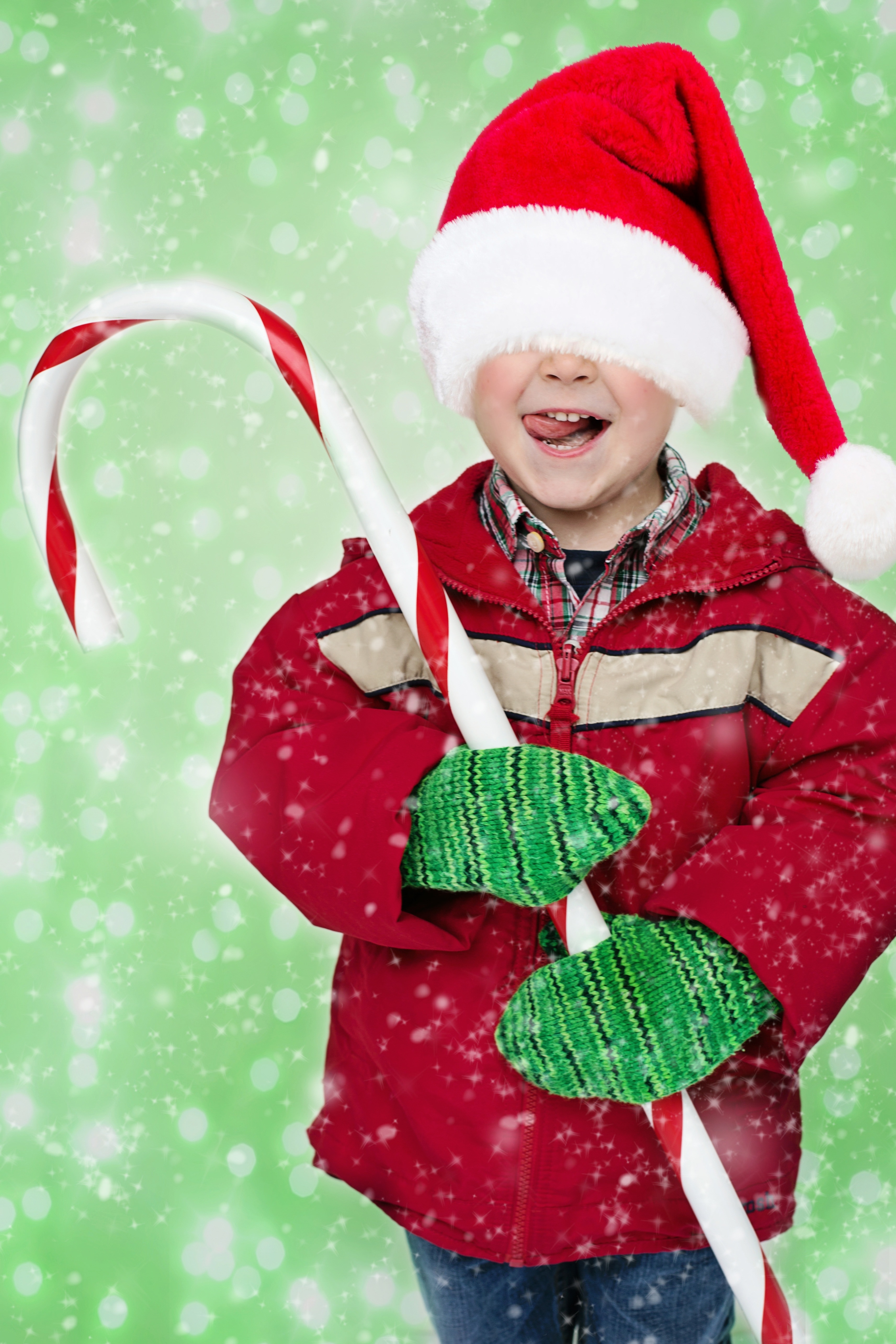 boy's red santa claus cap and candy cane