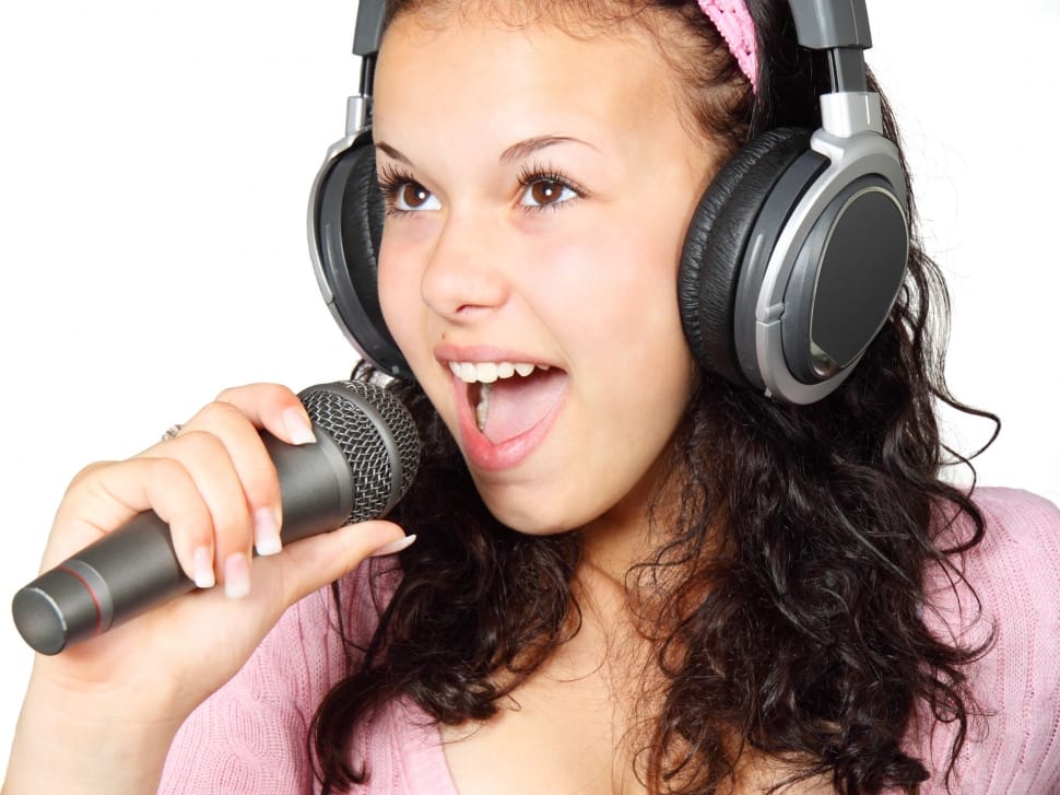 girl wearing headphones and singing using microphone preview
