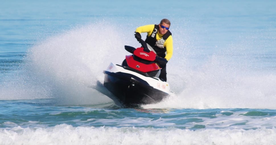 man riding a white,red, and black personal watercraft preview