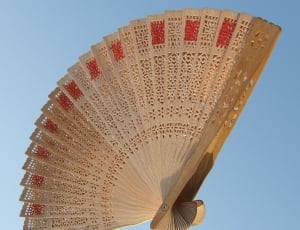 brown and red wooden hand fan thumbnail
