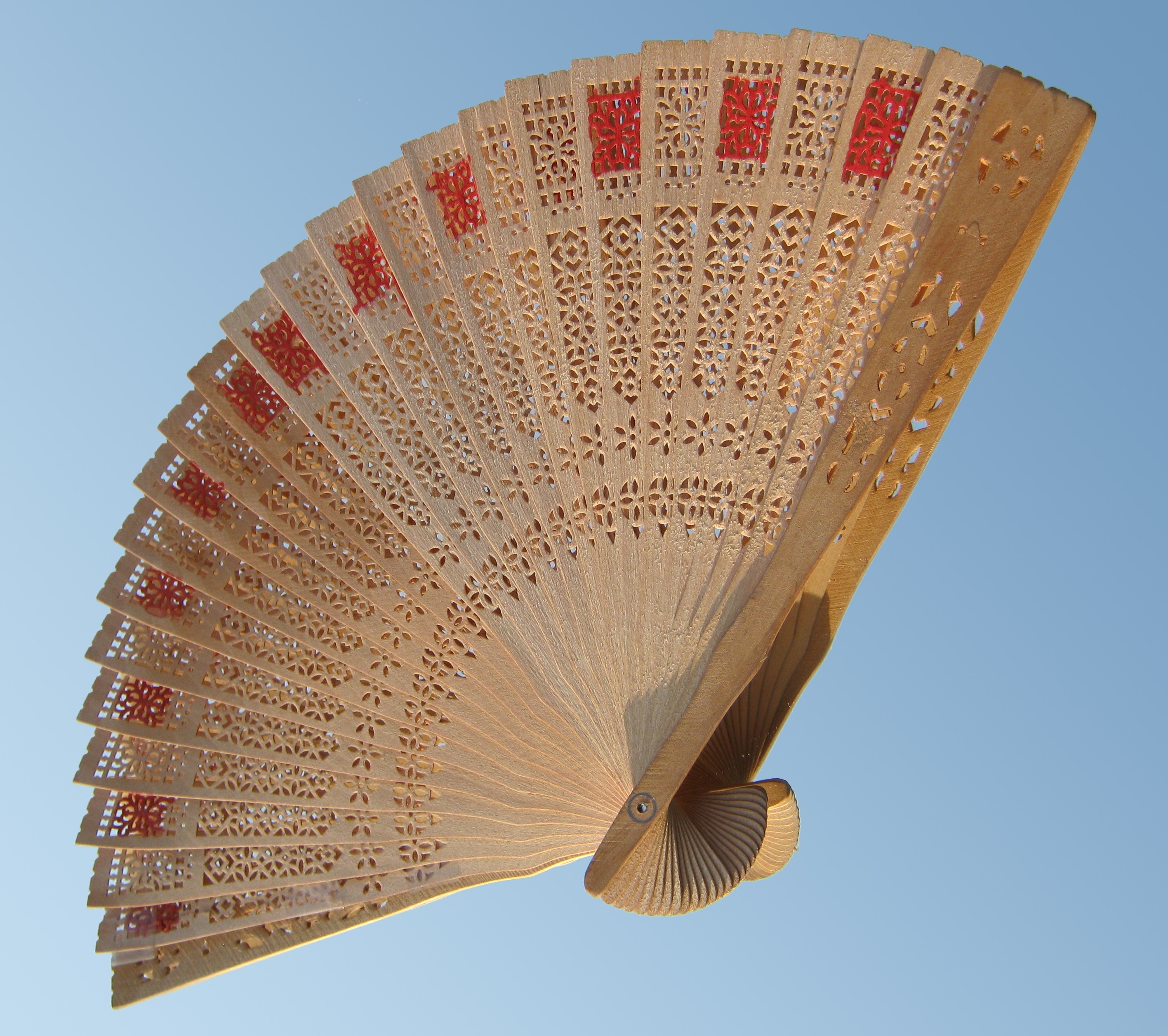 brown and red wooden hand fan