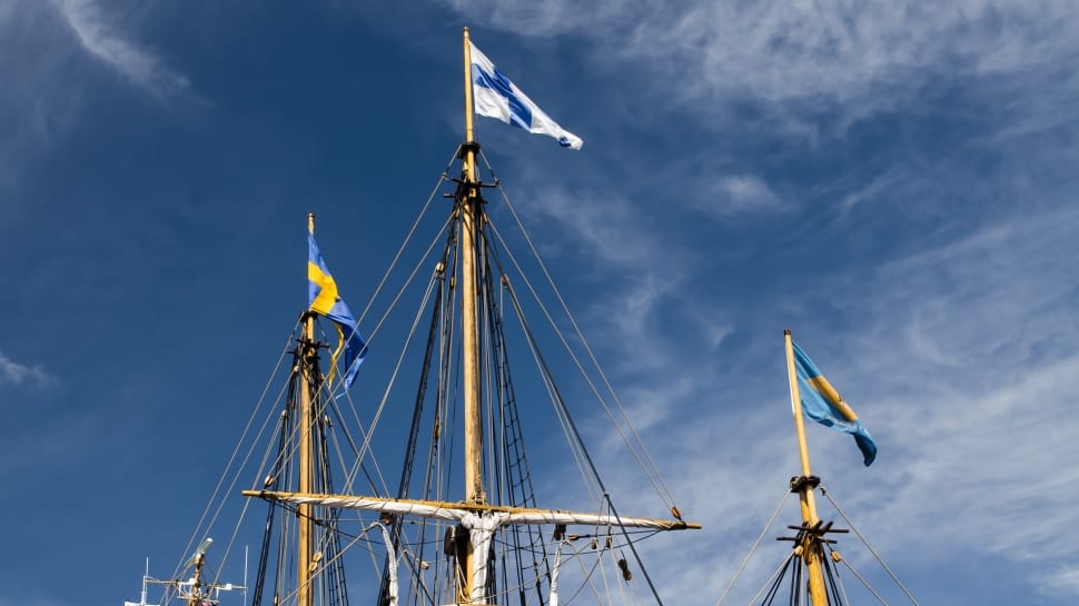 blue and white cross printed flag on ship during day time preview