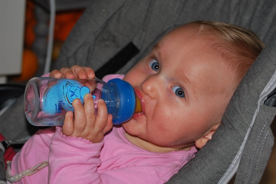 baby holding clear glass fedding bottle preview