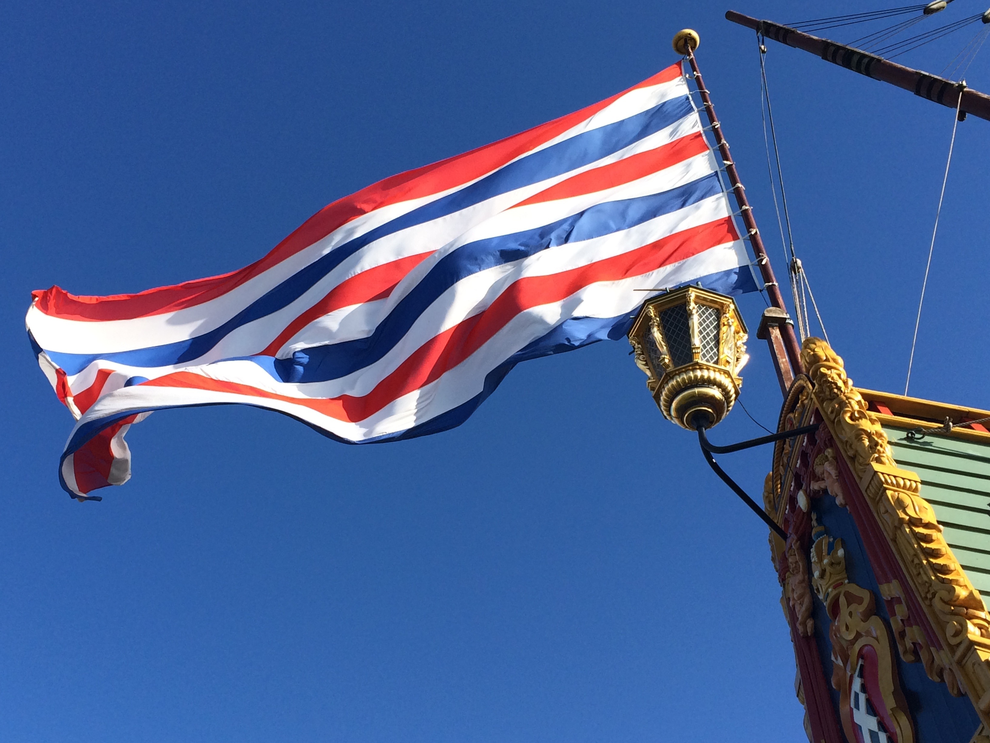red, white, and blue flag in brown pole