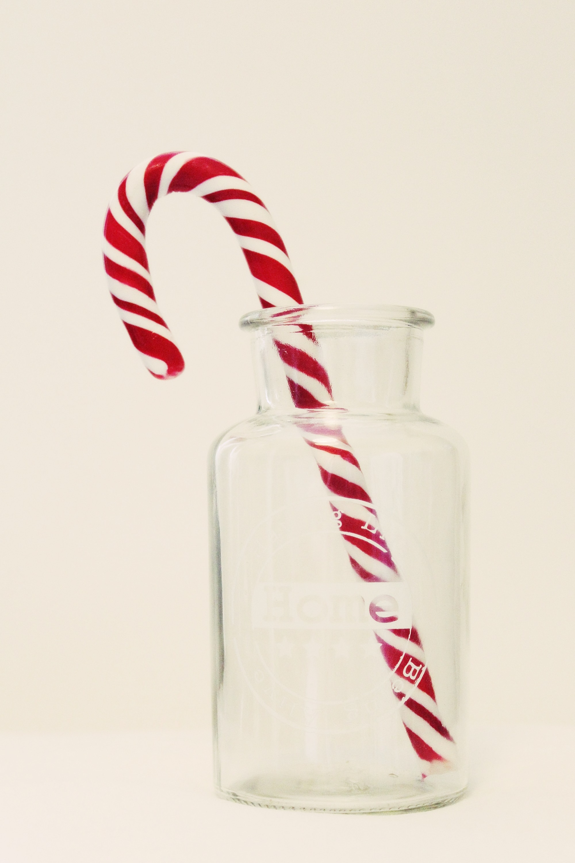 red and white candy cane and clear glass bottle