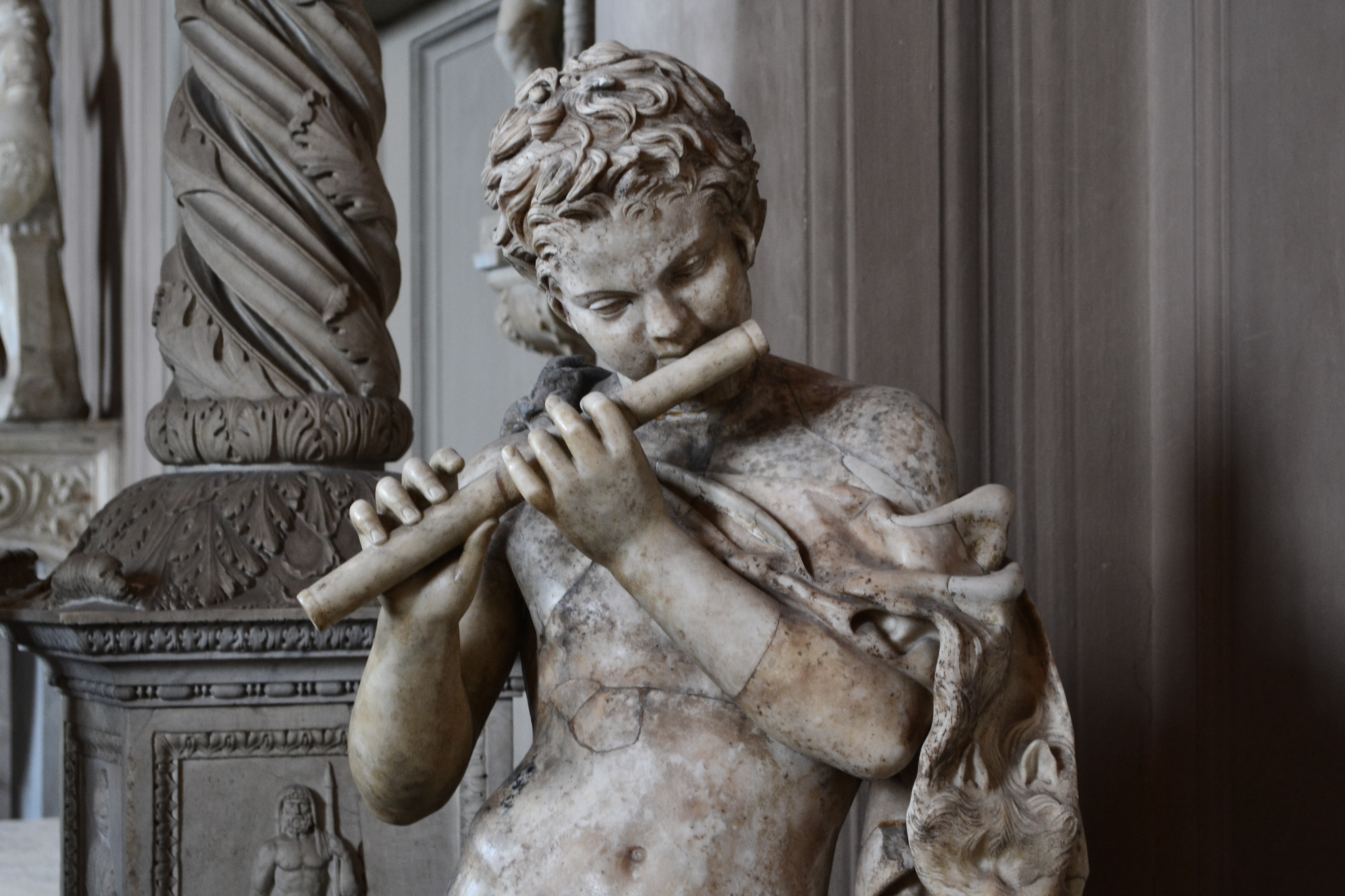 man playing flute concrete statue