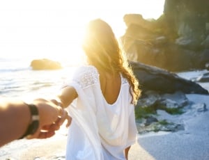 woman in white tops holding hand of person during daytime thumbnail